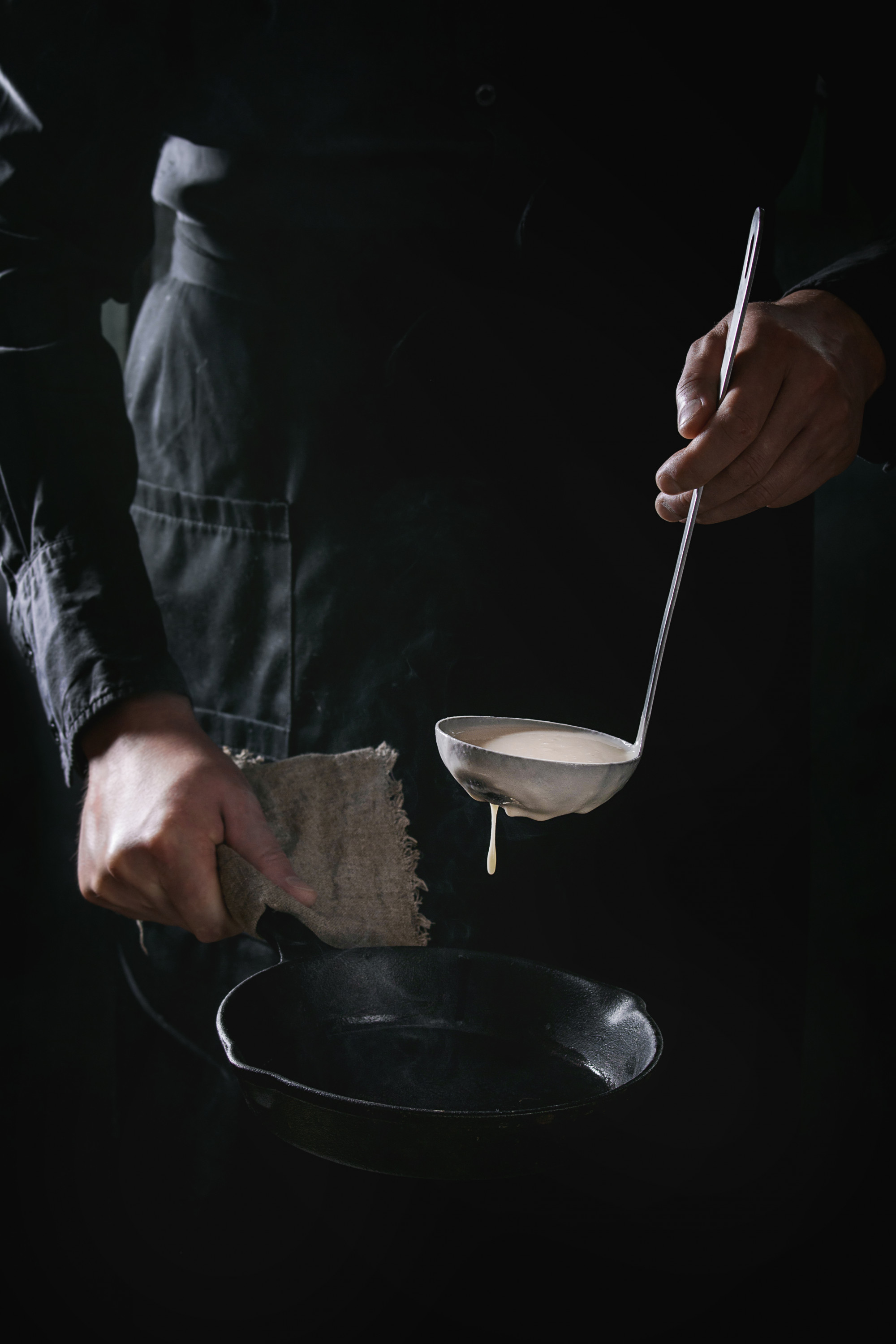 chef silhouette by window preparing plate